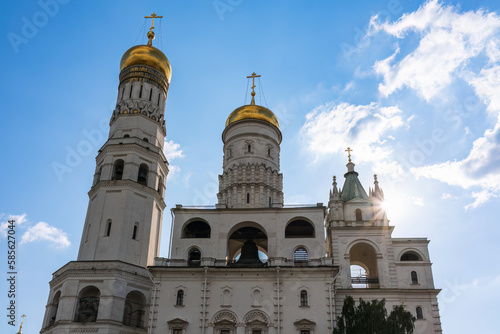 Ivan the Great Bell Tower, with Assumption Belfry on the right in Moscow Kremlin. Blue sky background with sunbeams