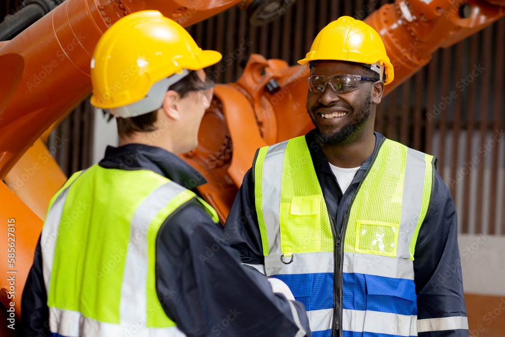 Two young engineer man handshake with partner for agreement while checking and maintenance robot arms technology at factory industrial, technician deal with partnership, industry concept. Two young engineer man handshake with partner for agreement while checking and maintenance robot arms technology at factory industrial, technician deal with partnership, industry concept.