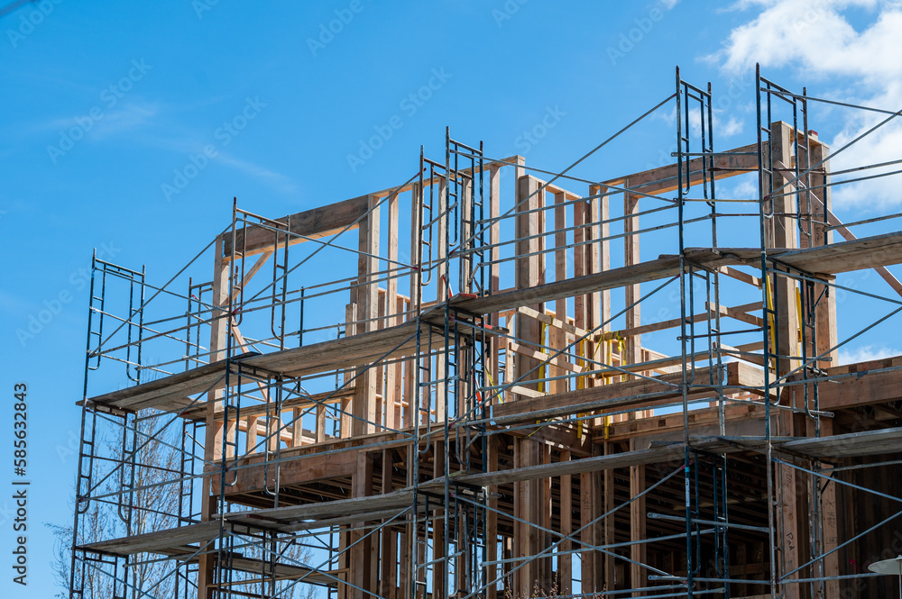 Multi-dwelling apartment building construction with framing and scaffolding