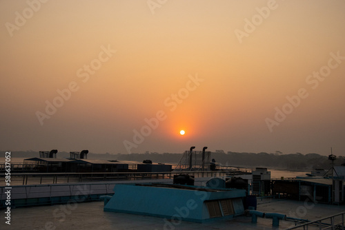 Beautiful Dawn with a sunrise view on a ship. Twilight view with sunset and water vessel. Beautiful sunset view on a ship at dusk time. Sky and tree horizon with sunrise scenery from a launch.