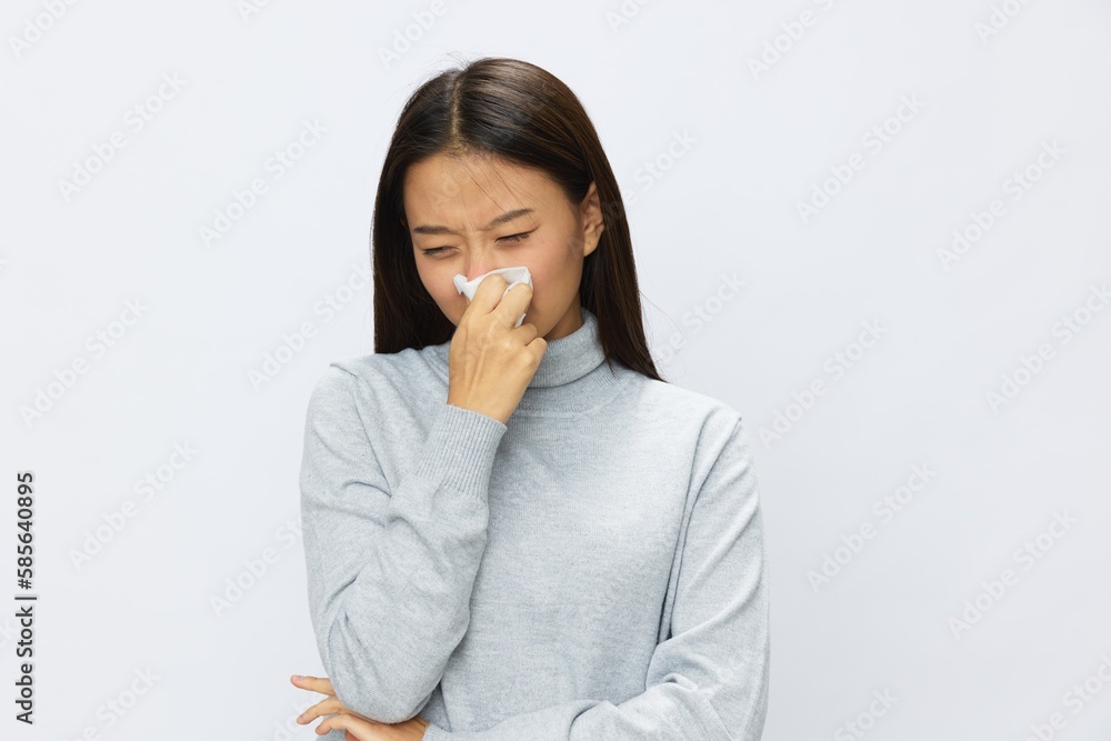 Sad Asian woman holding hand with handkerchief and coughing up flu and cold, stuffy nose viral disease asthma and allergies covid 19, white background Sad Asian woman holding hand with handkerchief and coughing up flu and cold, stuffy nose viral disease asthma and allergies covid 19, white background