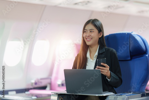 Beautiful Asian businesswoman working with laptop in aeroplane. working, travel, business concept