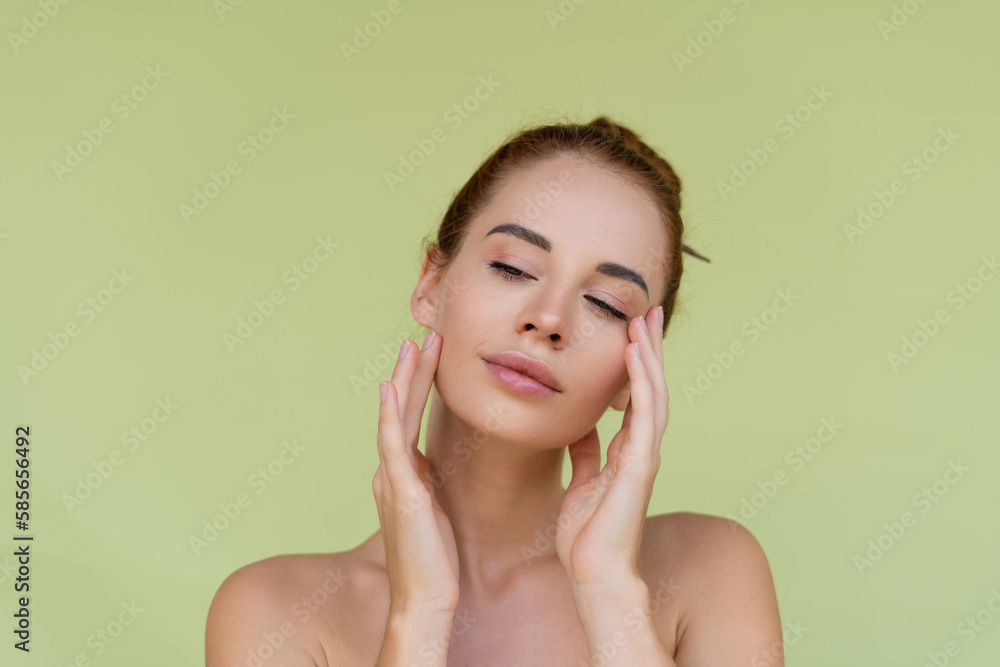 Beauty portrait of young topless red hair woman with bare shoulders on green background with perfect skin and natural makeup Beauty portrait of young topless red hair woman with bare shoulders on green background with perfect skin and natural makeup