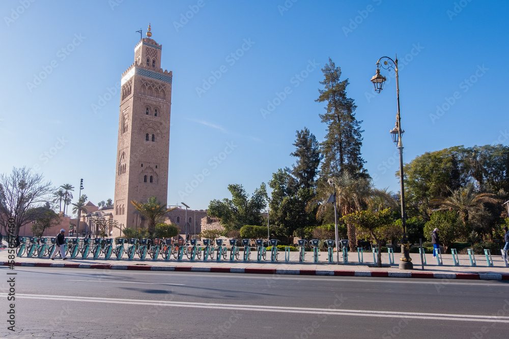 A Marrakech mosque seen from across a wide downtown street