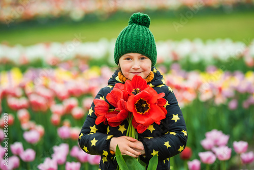 Canvas Print Child holding a big bouquet of red tulips