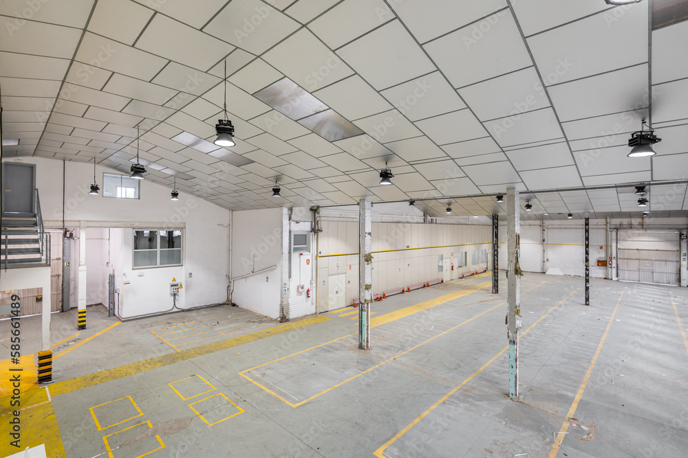 Obraz premium Top view of an empty auto repair shop or car park with natural light. Concept of redesigning the purpose of the premises. Factory or warehouse space