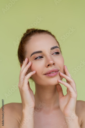 Beauty portrait of young topless red hair woman with bare shoulders on green background with perfect skin and natural makeup