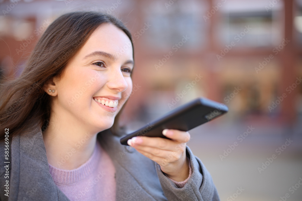 Happy woman in winter dictating on phone Happy woman in winter dictating on phone