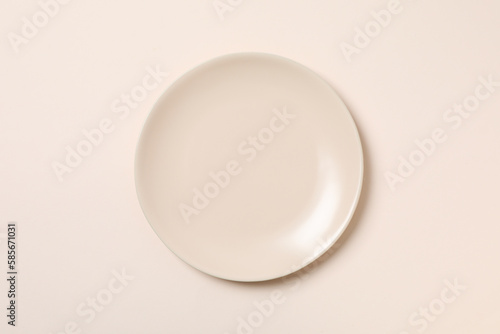 Empty plate on beige background, top view