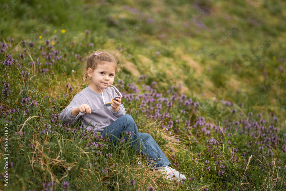 Little girl enjoying nice and sunny spring day near blooming apple tree in Prague park Little girl enjoying nice and sunny spring day near blooming apple tree in Prague park