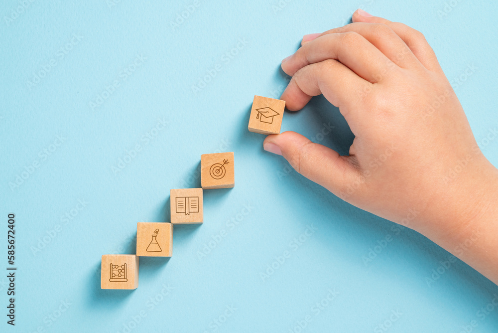 Obraz premium Student organizing wooden cubes with education icons. Education concept