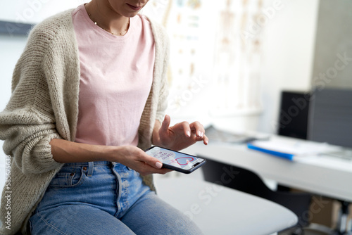 Woman using mobile app on smart phone in medical clinic photo