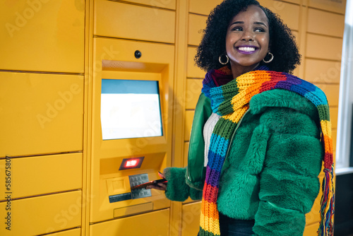 Happy woman standing near ticket vending machine photo