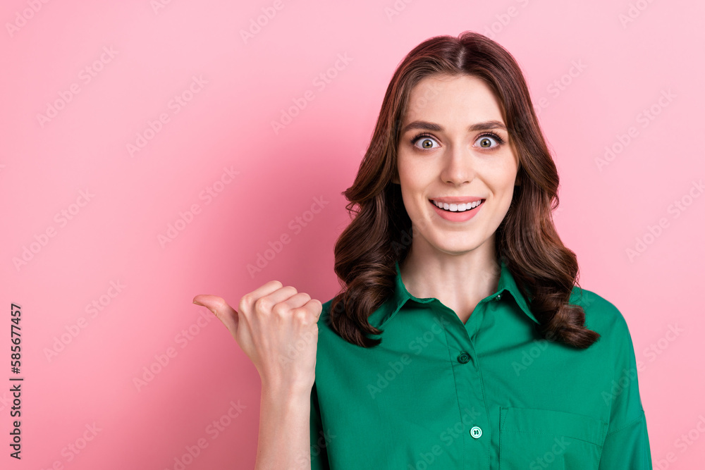 Photo of astonished cheerful manager lady toothy smile direct finger empty space isolated on pink color background Photo of astonished cheerful manager lady toothy smile direct finger empty space isolated on pink color background