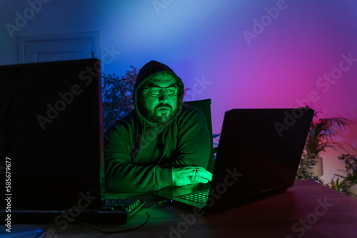 Hacker with computers on desk at home photo