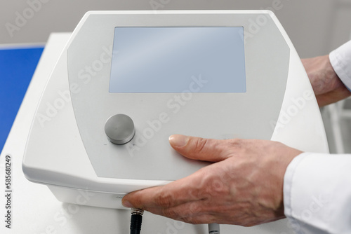 Closeup photo of male therapist using modern tecar machine photo