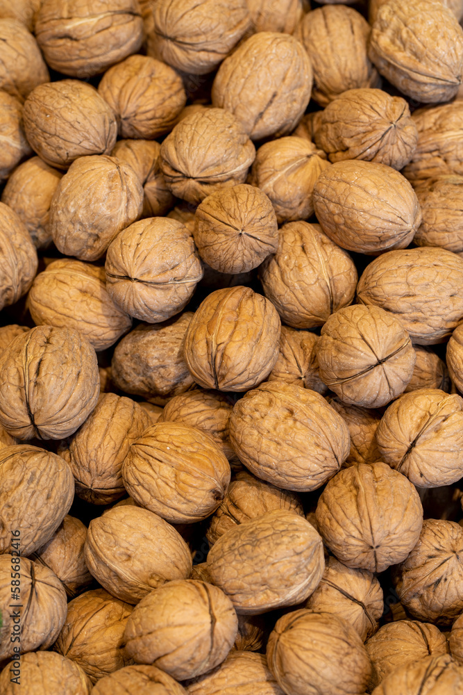 Shelled walnuts. Pile of unshelled walnuts in daylight. Walnut background. Shelled walnuts. Pile of unshelled walnuts in daylight. Walnut background.
