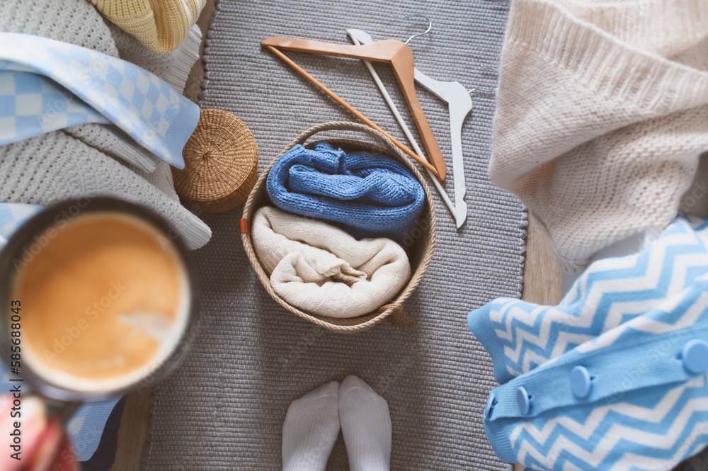 Morning home routine. Woman organizing clothes, many knitted sweaters ...