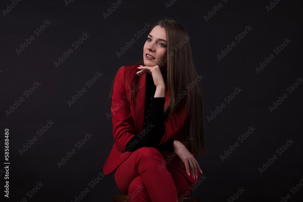 Portrait of a businesswoman in a red suit on a black background. Portrait of a businesswoman in a red suit on a black background.