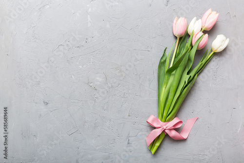 Bouquet of pink tulips on colored table background . Top view with copy space. Waiting for spring. Happy Easter card. Flat lay