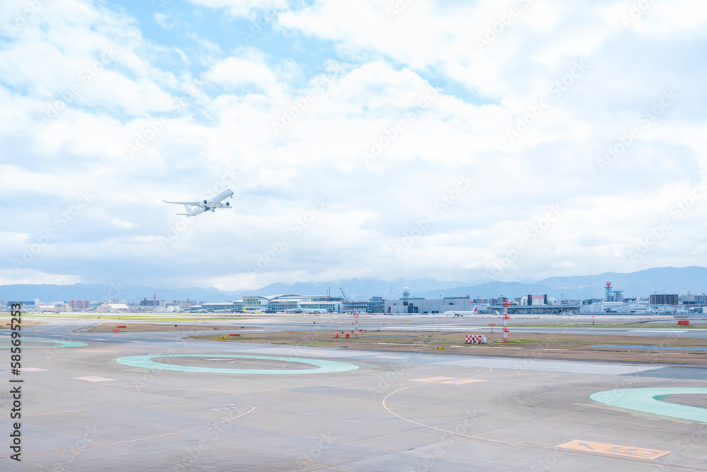 福岡空港の滑走路を離陸して青空に飛んでいく旅客機