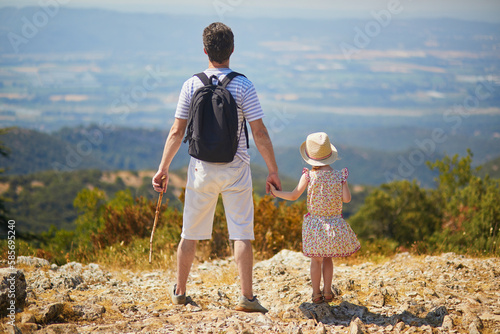 Father and daughter enjoying beautiful view from the top of the hill in Provence, Southern France