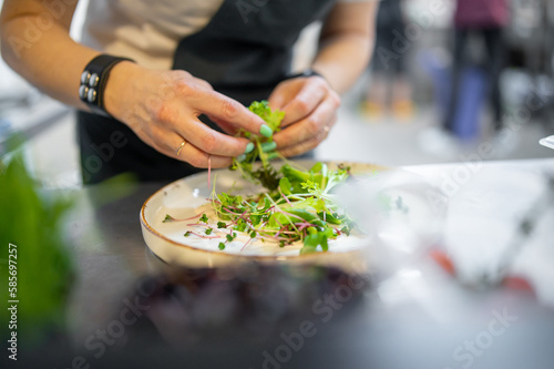 Chef cooking vegetables salad on restaurant kitchen