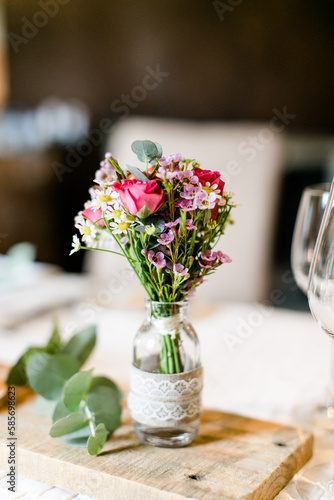 Blumendeko auf Holzbrett bei einer Hochzeitsfeier