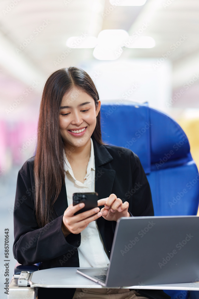 Beautiful Asian business woman chatting with client by mobile phone during flight. working, travel, business concept Beautiful Asian business woman chatting with client by mobile phone during flight. working, travel, business concept