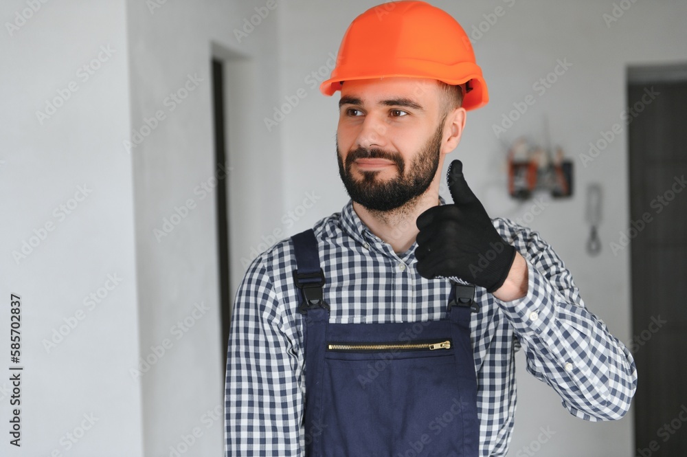 Portrait of positive, handsome young male builder in hard hat Portrait of positive, handsome young male builder in hard hat