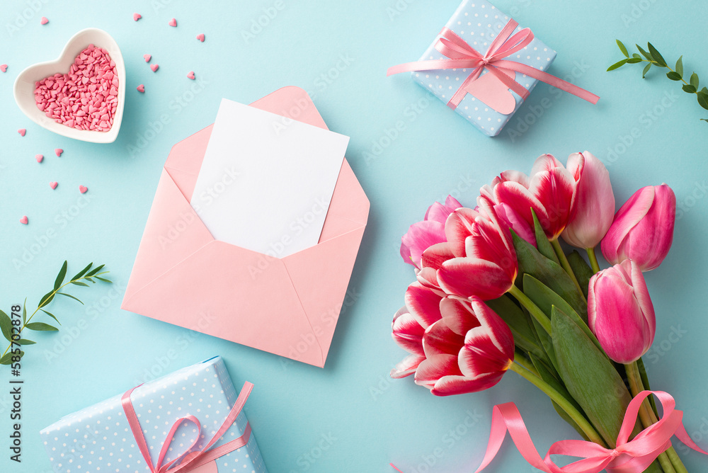 Mother's Day concept. Top view photo of bunch of tulips gift boxes with bows envelope with paper sheet and heart shaped saucer with sprinkles on isolated pastel blue background with blank space Mother's Day concept. Top view photo of bunch of tulips gift boxes with bows envelope with paper sheet and heart shaped saucer with sprinkles on isolated pastel blue background with blank space