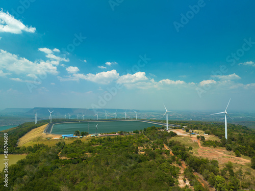 aerial view above a Group of Wind turbine on mountain at day time in Lam Takong Dam, Nakhon Ratchasima, Thailand white cloud in blue sky background.Wind power generates electricity. Clean energy from 