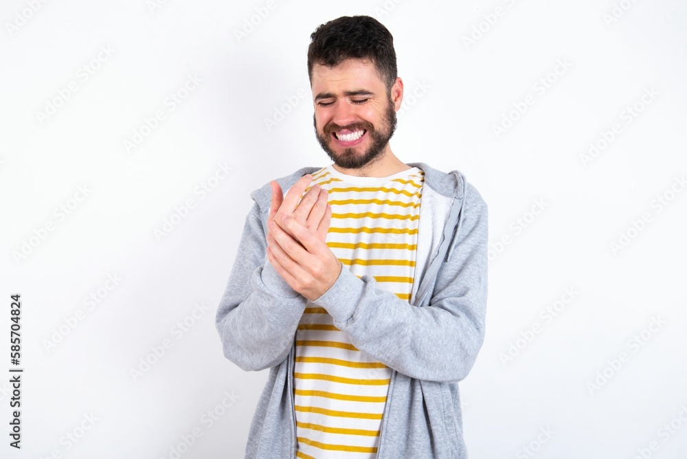 Young caucasian mán wearing trendy clothes over white background Suffering pain on hands and fingers, arthritis inflammation Young caucasian mán wearing trendy clothes over white background Suffering pain on hands and fingers, arthritis inflammation