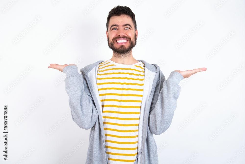 Cheerful cheery optimistic Young caucasian mán wearing trendy clothes over white background holding two palms copy space Cheerful cheery optimistic Young caucasian mán wearing trendy clothes over white background holding two palms copy space
