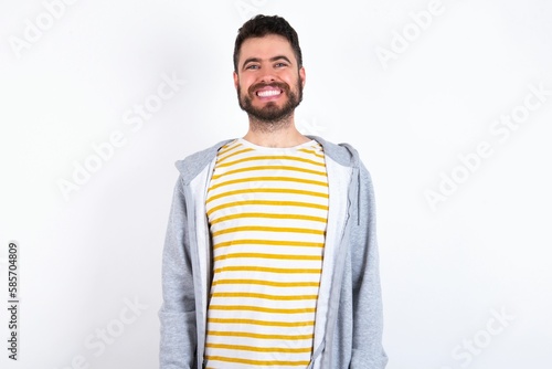 Young caucasian mán wearing trendy clothes over white background with a happy and cool smile on face. Lucky person.