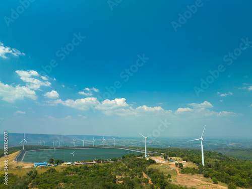 aerial view above a Group of Wind turbine on mountain at day time in Lam Takong Dam, Nakhon Ratchasima, Thailand white cloud in blue sky background.Wind power generates electricity. Clean energy from 