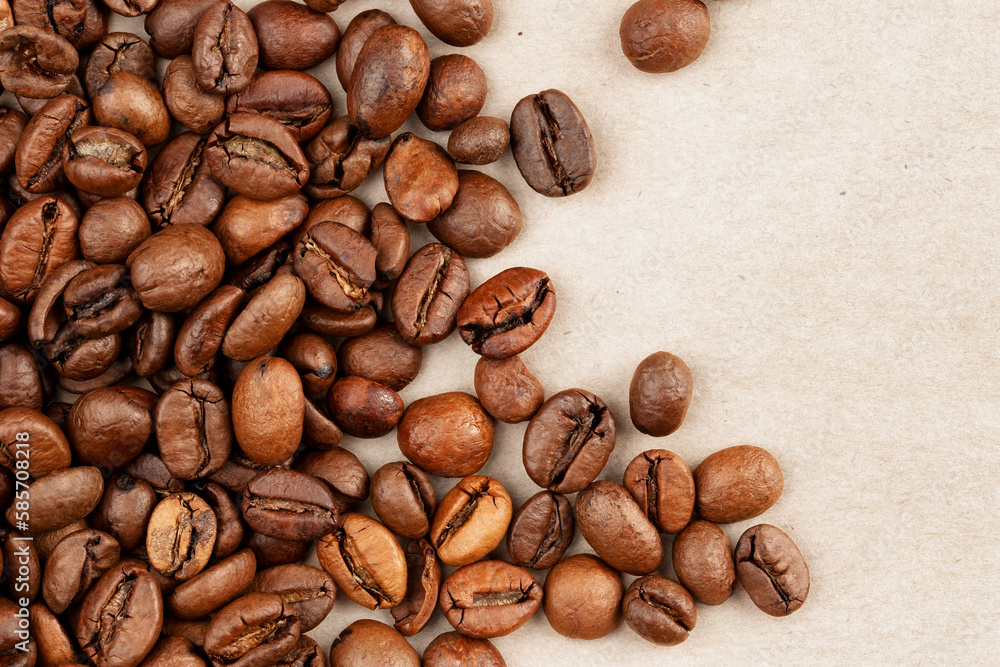 roasted whole arabica coffee beans, scattered on paper, isolated roasted whole arabica coffee beans, scattered on paper, isolated