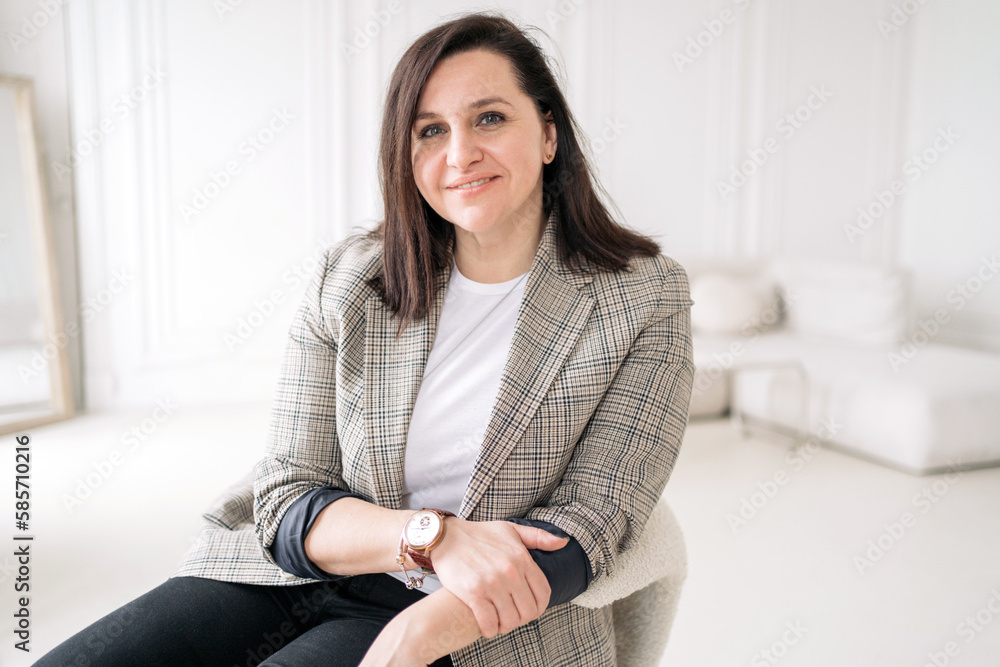A woman psychologist in business clothes confident work in the office sitting in an armchair. A happy person at work every day. A woman psychologist in business clothes confident work in the office sitting in an armchair. A happy person at work every day.
