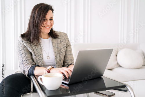 Video call with a colleague discussing a new startup. A confident woman working in an office using an online laptop.