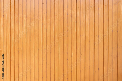 Hell honigfarben lasierte Holzwand aus genagelten vertikalen Brettern