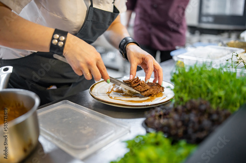 Chef cooking Roasted Duck breast fillets with vegetable pure on restaurant kitchen