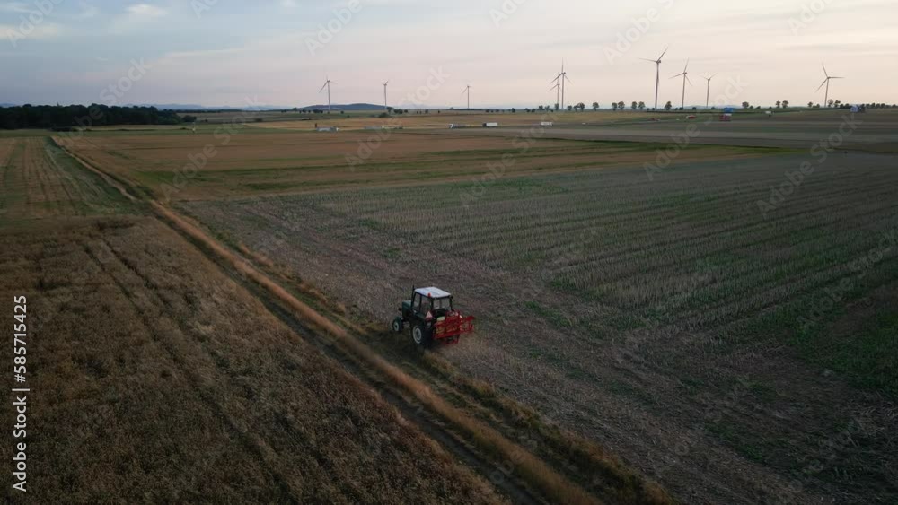 Farm tractor working in agricultural field, cultivating and plowing soil, drone view. Agribusiness concept. Small farming Farm tractor working in agricultural field, cultivating and plowing soil, drone view. Agribusiness concept. Small farming