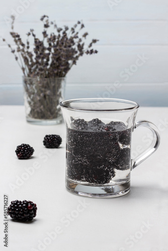 Blackberry summer drink in a glass mug. Lavender in glass.