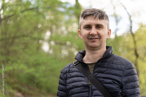 A middle-aged man with graying in a thin down jacket in early spring. © Tatiana Kolosovskaya