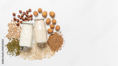 Variety of vegan plant based milk in glass bottles. Top view of lactose free milk based on nuts, legumes, oatmeal on white background photo