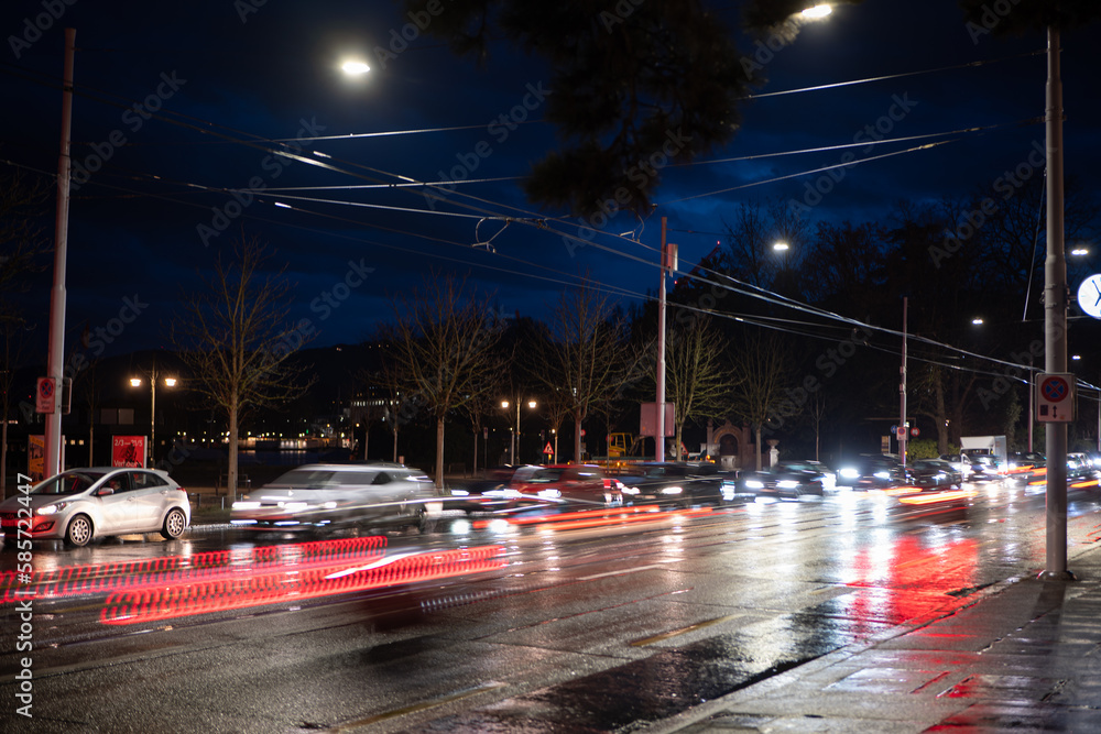 Heavy car traffic at night in a European city. Long exposure, car light trails, traffic light, late evening