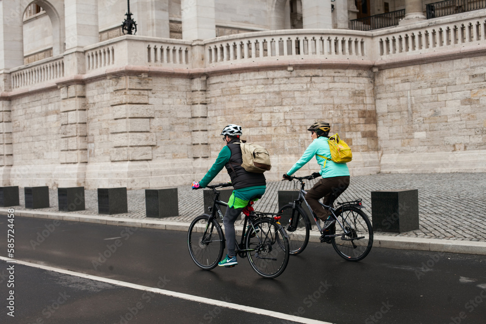 People  riding bicycles on streets of Budapest. Cycling in Europe. Cyclist on the road side view.