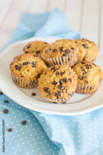Classic muffins with chocolate chips for breakfast on blue and white background close up selective focus