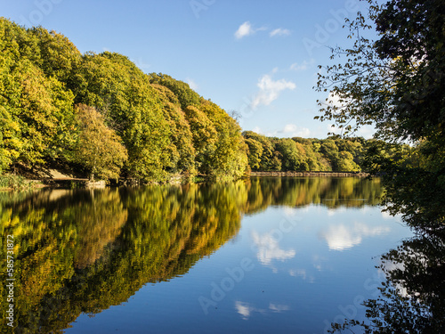 On a still late summer day the sky and trees are reflected in the reservoir at Chellow Dene one of Bradford District's favourite spots for fresh air and relaxing exercise photo