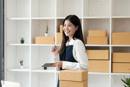 Small business entrepreneur SME freelance,Portrait young woman thinking and looking on laptop at home office, online marketing packaging delivery box, SME e-commerce concept